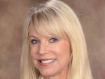 Cathy Sturdivant has a blonde hair as she is smiling for the camera in this picture.